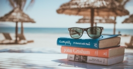 Sonnebrille auf Büchern am Meer
